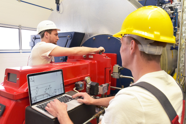 Arbeiter stellen Maschine für Produktion ein